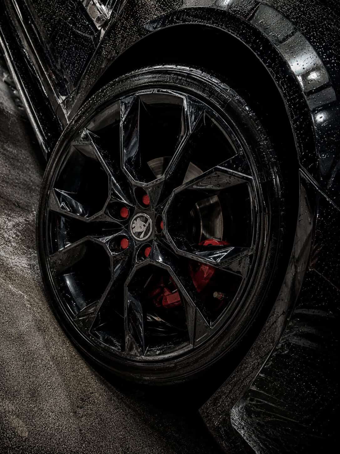 Detail čistého kola s červenými brzdovými třmeny